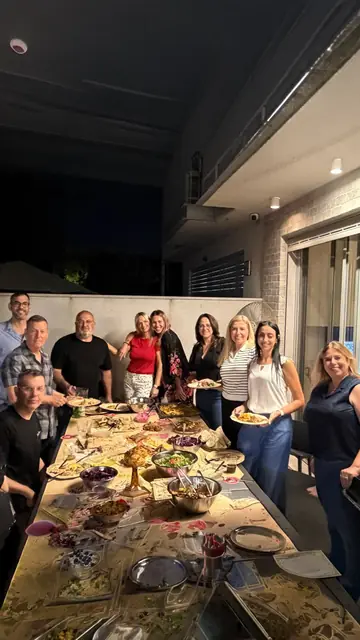 צוות סביב שולחן ארוך מלא אוכל